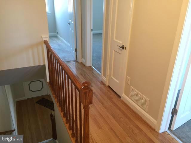 362 Grovethorn Road Baltimore, MD 21220 - Photo 6 of 14 a view of a hallway with wooden floor and staircase