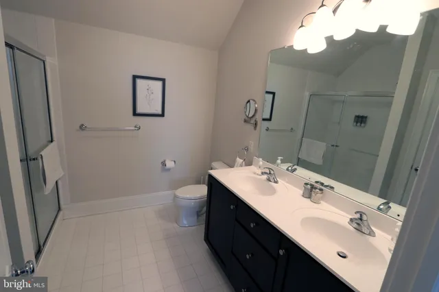a bathroom with a double vanity sink mirror and toilet
