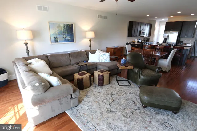 a living room with furniture kitchen view and a lamp