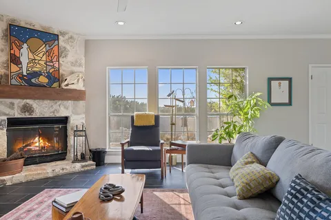 a living room with furniture a fireplace and a wall painting