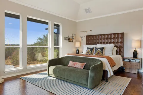 a spacious bedroom with a bed and wooden floor