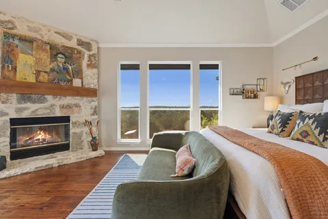 a bed sitting in a bedroom next to a fireplace with a window