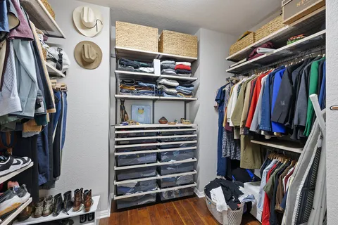 a view of walk in closet with clothes and shoes