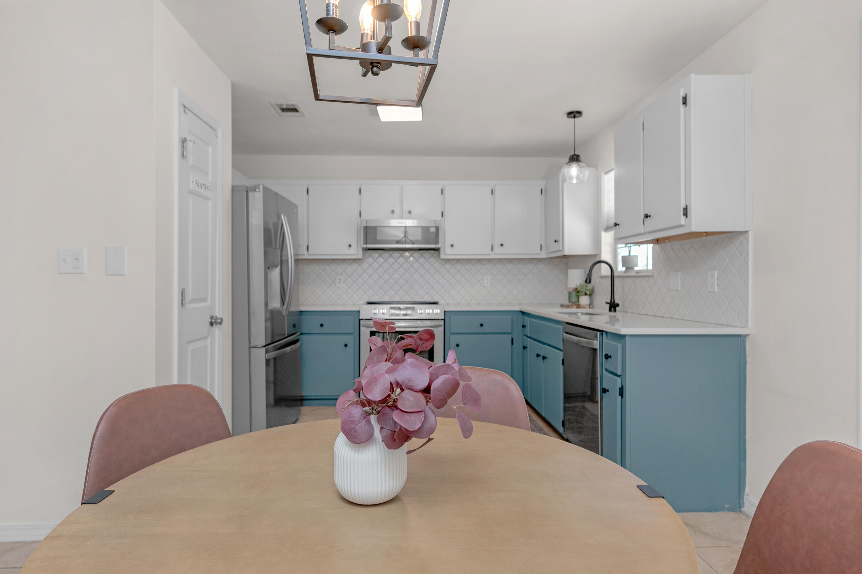 2709 Augustus Road Navarre, FL 32566 - Photo 12 of 46 a kitchen with stainless steel appliances granite countertop a sink dishwasher a stove a dining table and chairs with wooden floor