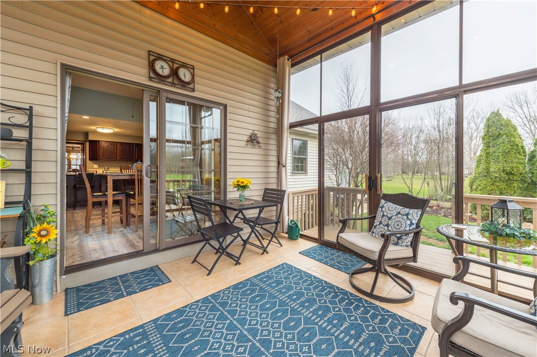 44565 Stang Road Elyria, OH 44035 - Photo 39 of 50 Sunroom with wood walls, a high wooden ceiling, tile patterned floors, and floor to ceiling windows