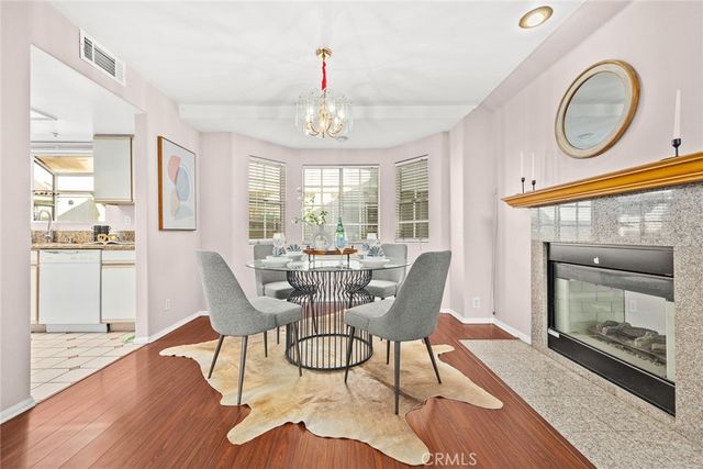 a dining room with furniture a fireplace and wooden floor