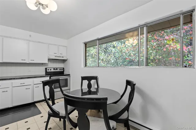 a kitchen with granite countertop white cabinets and a stove