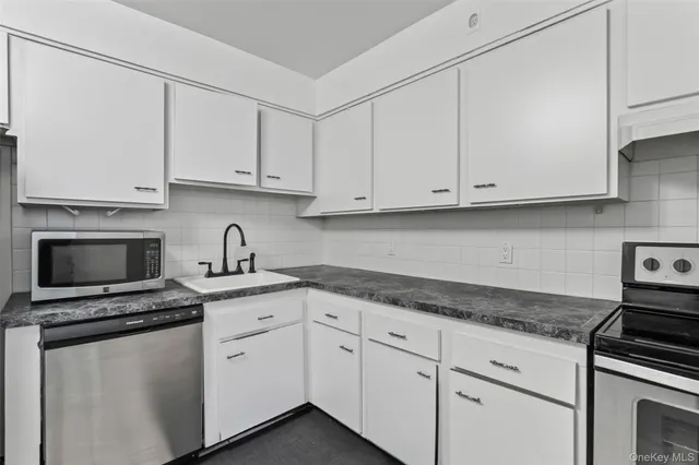 a kitchen with stainless steel appliances granite countertop a dining table and chairs