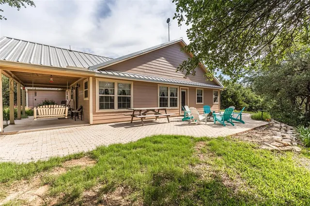 a front view of a house with swimming pool and furniture