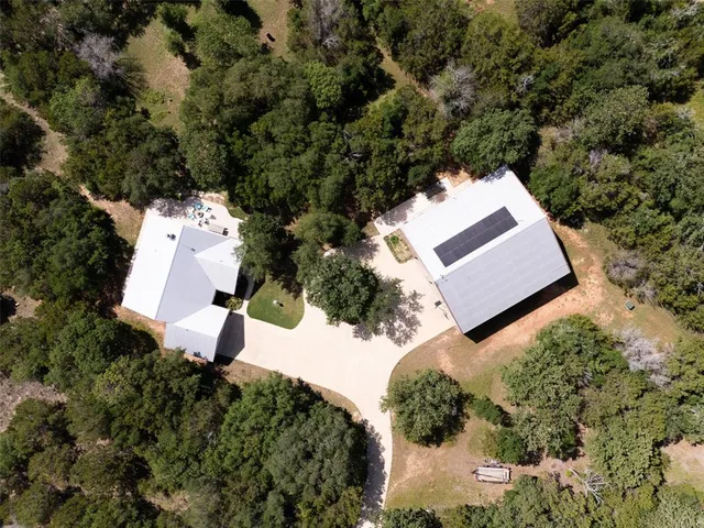an aerial view of a house with a yard and trees