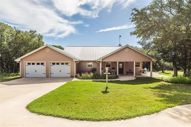 a front view of house with yard and garage