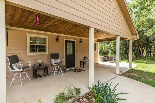 a view of a patio with table and chairs and a barbeque