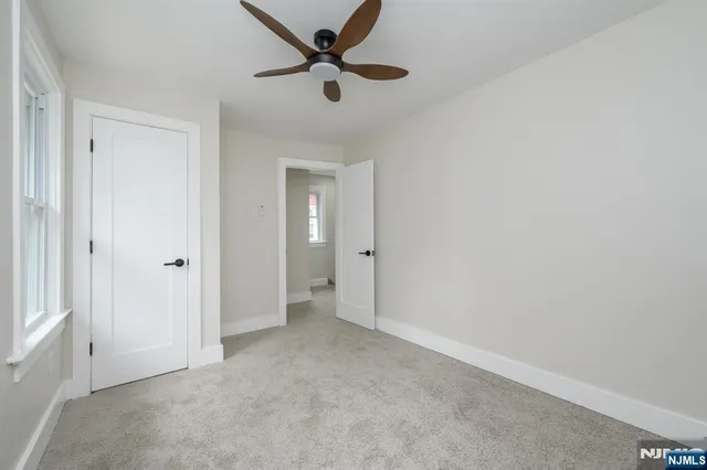 an empty room with closet and windows