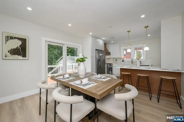 a kitchen with a dining table chairs and refrigerator