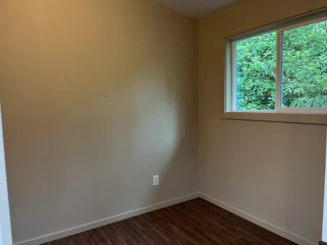 a view of a small space with wooden floor and a window