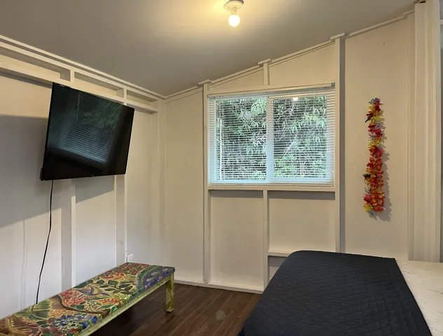 a bedroom with a bed and flat screen tv