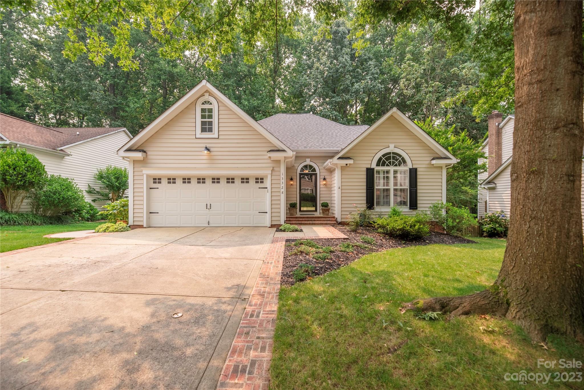 a view of a house with a yard and large tree
