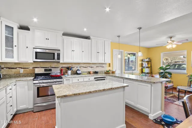 a kitchen with stainless steel appliances granite countertop a sink stove and cabinets