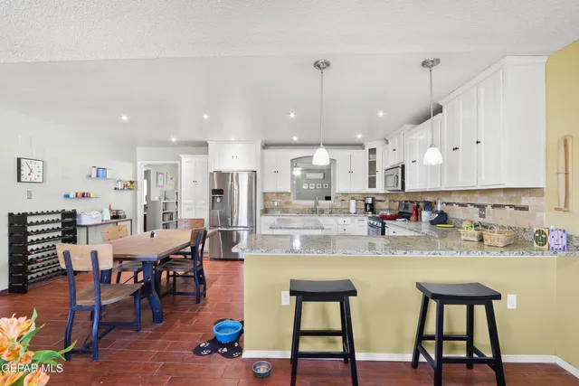 a kitchen with stainless steel appliances granite countertop white cabinets and stove