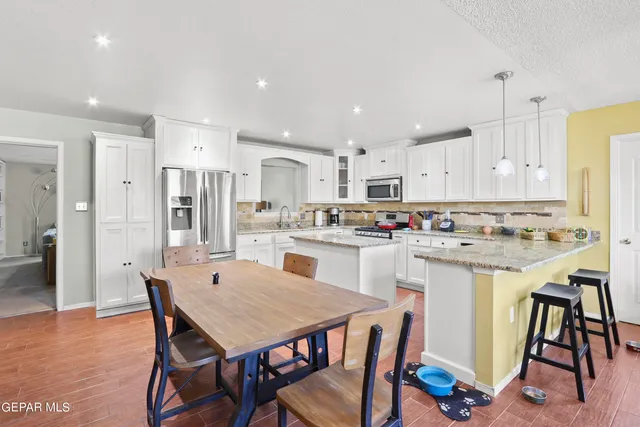 a kitchen with granite countertop stainless steel appliances white cabinets sink and dishwasher