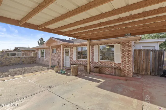 a view of a patio with table and chairs with wooden fence