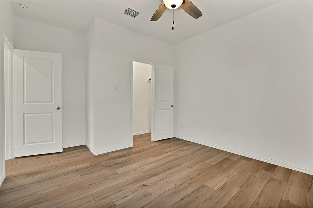 3204 Renaissance Drive Denton, TX 76207 - Photo 23 of 25 Room featuring wood-finish flooring, crisp white walls, white trim, and a ceiling fan with light fixture
