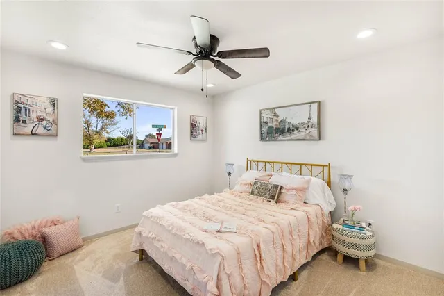 a bedroom with a bed and painting on the wall