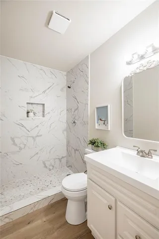 a bathroom with a sink a toilet and shower