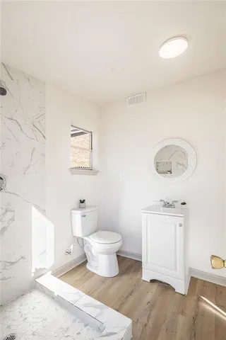 a bathroom with a toilet sink and mirror