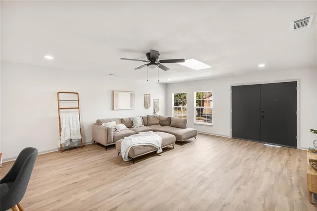 a living room with furniture and a ceiling fan