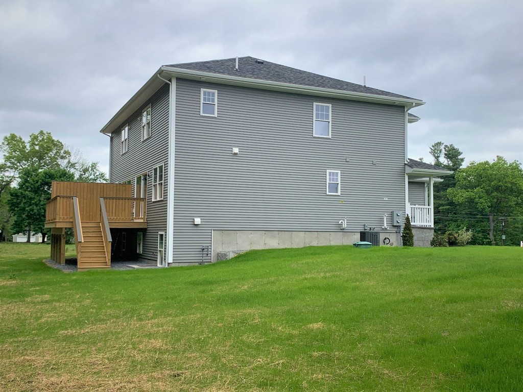 25 Shaker Road, Unit B Ayer, MA 01432 - Photo 15 of 16 a front view of a house with a yard