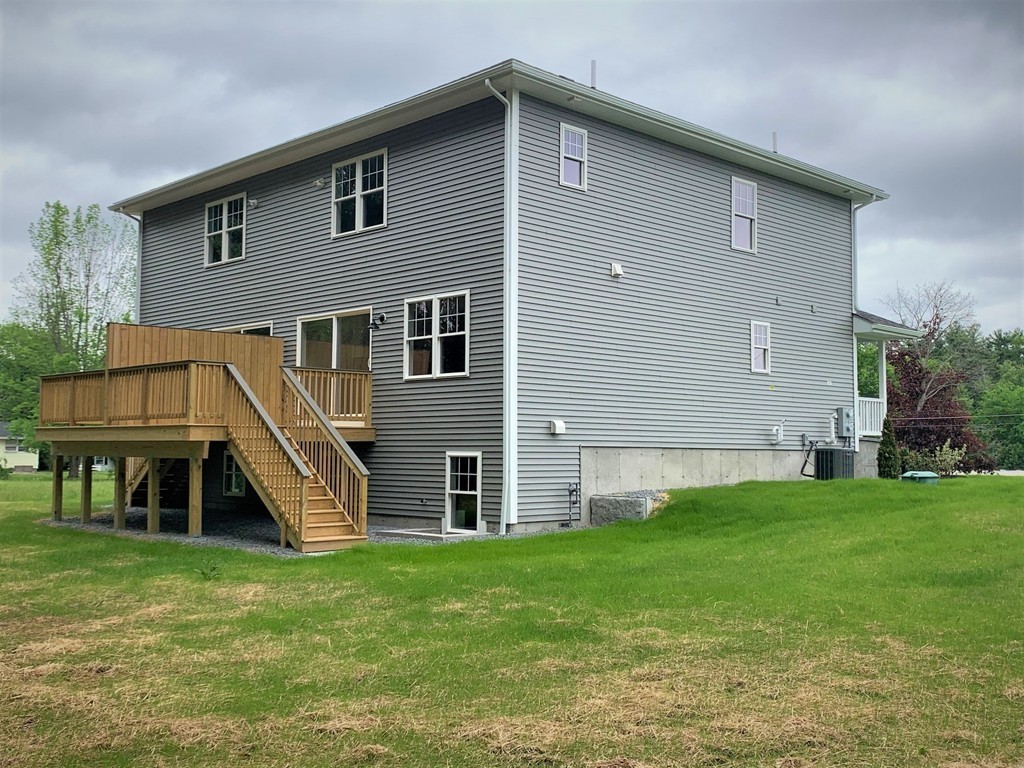 25 Shaker Road, Unit B Ayer, MA 01432 - Photo 16 of 16 a front view of a house with a yard