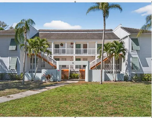 a view of a house with backyard and a tree