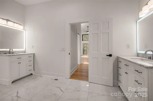 a spacious bathroom with a granite countertop sink a mirror and a