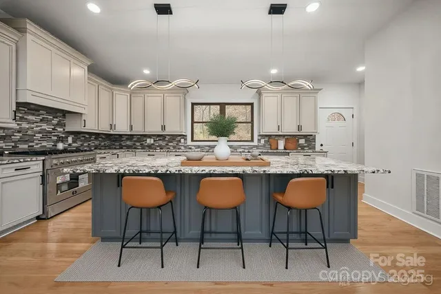a kitchen with stainless steel appliances granite countertop a stove a sink and a microwave