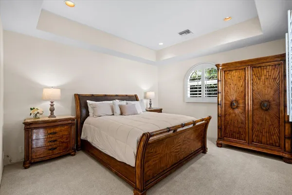 a bed sitting in a spacious bedroom next to a window