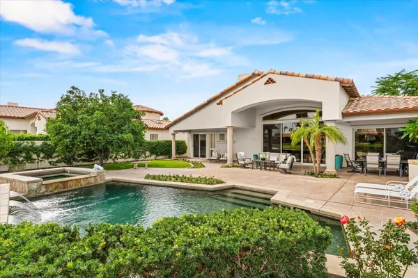 a view of a house with swimming pool and sitting area
