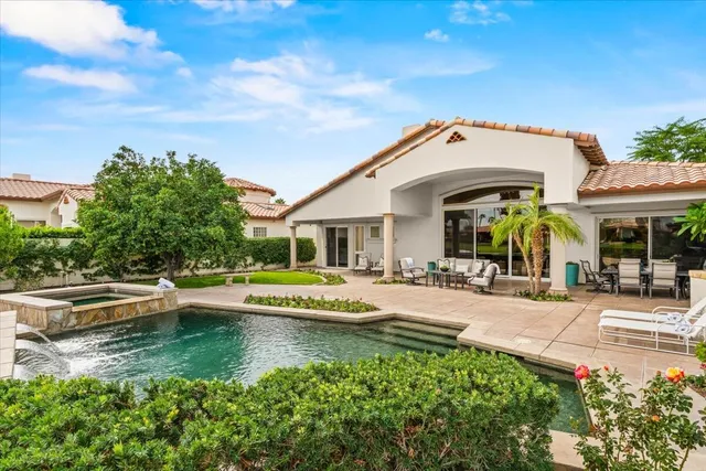 a view of a house with swimming pool and sitting area