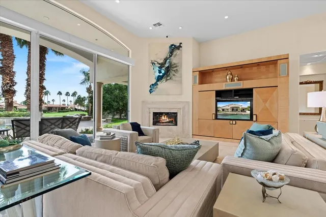 a living room with furniture fireplace and a large window