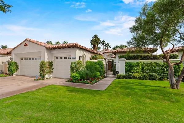 a front view of a house with a yard and potted plants