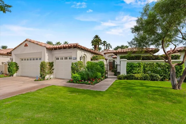 a front view of a house with a yard and potted plants