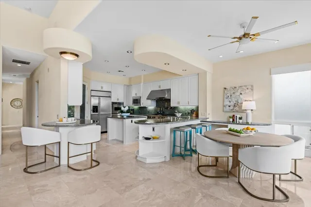 a kitchen with a dining table chairs and white cabinets