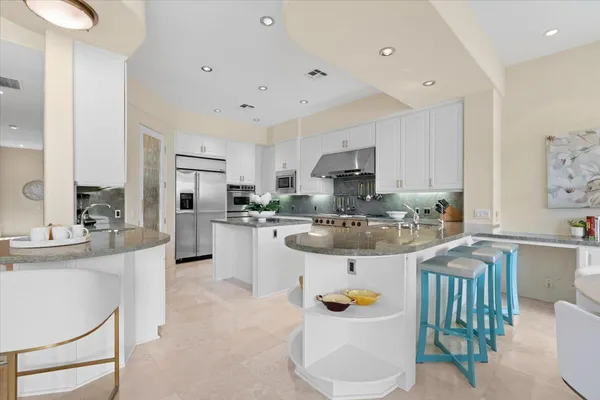 a kitchen with stainless steel appliances kitchen island granite countertop a sink and cabinets