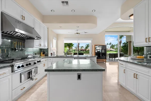a kitchen with stainless steel appliances granite countertop a sink a stove and a wooden floors