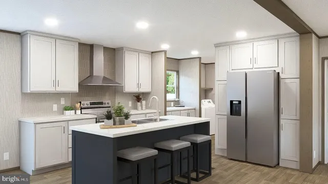 a kitchen with stainless steel appliances a sink a refrigerator and white cabinets