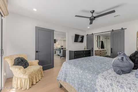 a bedroom with a bed dresser and a large mirror