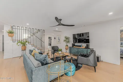 a living room with furniture a flat screen tv and kitchen view