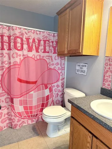 a bathroom with a granite countertop toilet sink and mirror