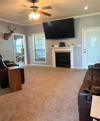 a living room with furniture a flat screen tv and a fireplace