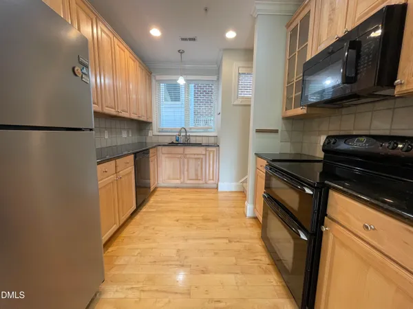 a kitchen with stainless steel appliances granite countertop a stove a sink and a microwave